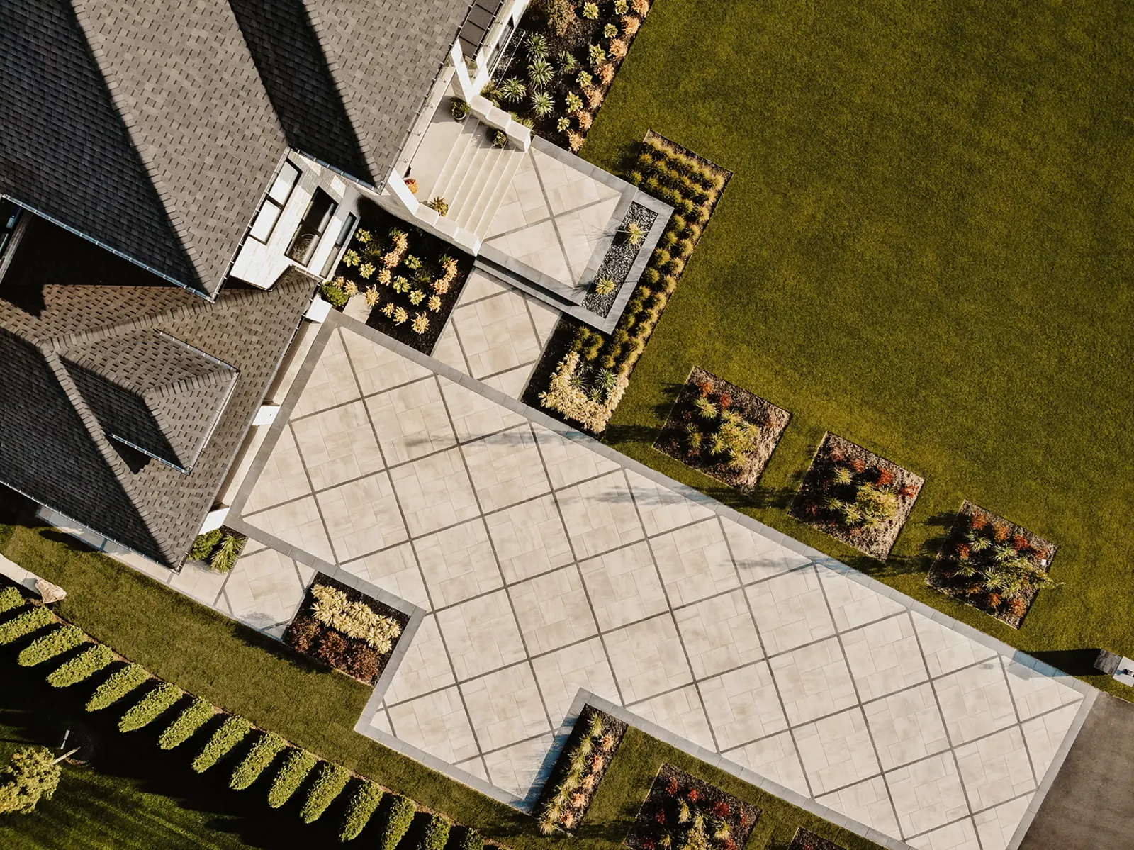 Aerial view of a house and its yard with a Proma slab patio in Oka beige