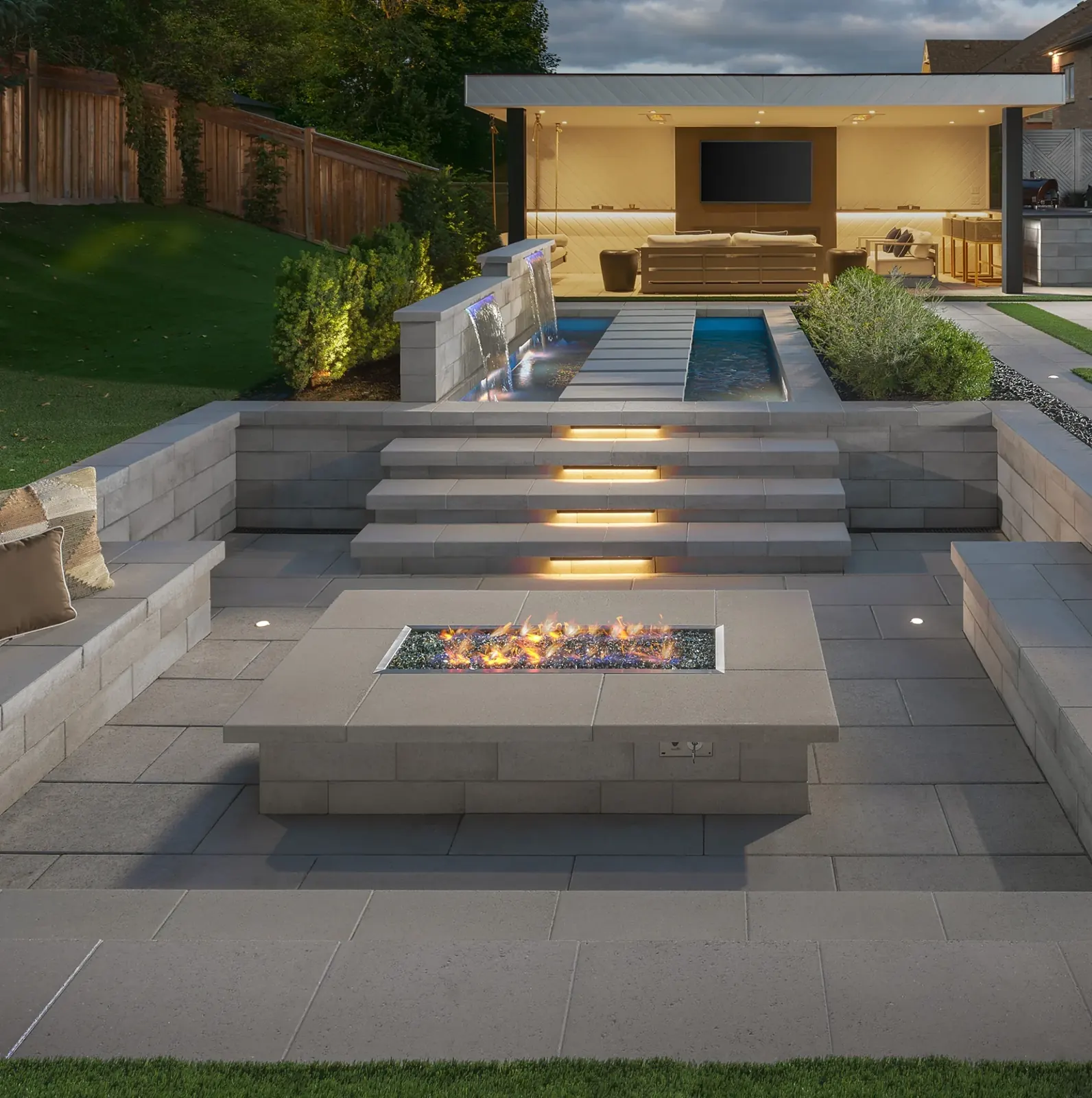 Outdoor fire pit and lit steps at dusk
